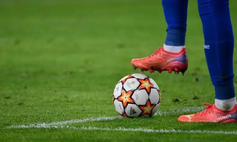 Un joueur qui a un pied sur un ballon de foot