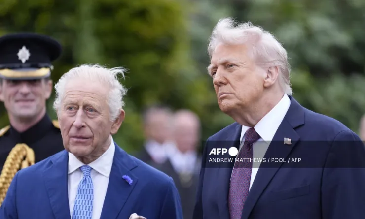 Britain’s King Charles III (L) and US President Donald Trump (R) speak to military personnel following a Beating Retreat military ceremony on the East Lawn at Windsor Castle, in Windsor, on September 17, 2025, during the US President’s second State Visit. US President Donald Trump arrived in Britain for an unprecedented second State Visit, with the UK government rolling out a royal red carpet welcome to win over the mercurial leader. (Photo by Andrew Matthews / POOL / AFP)