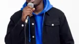Portrait de Kweku Smoke tenant un microphone